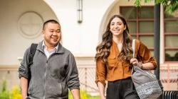 two students walking and smiling on campus